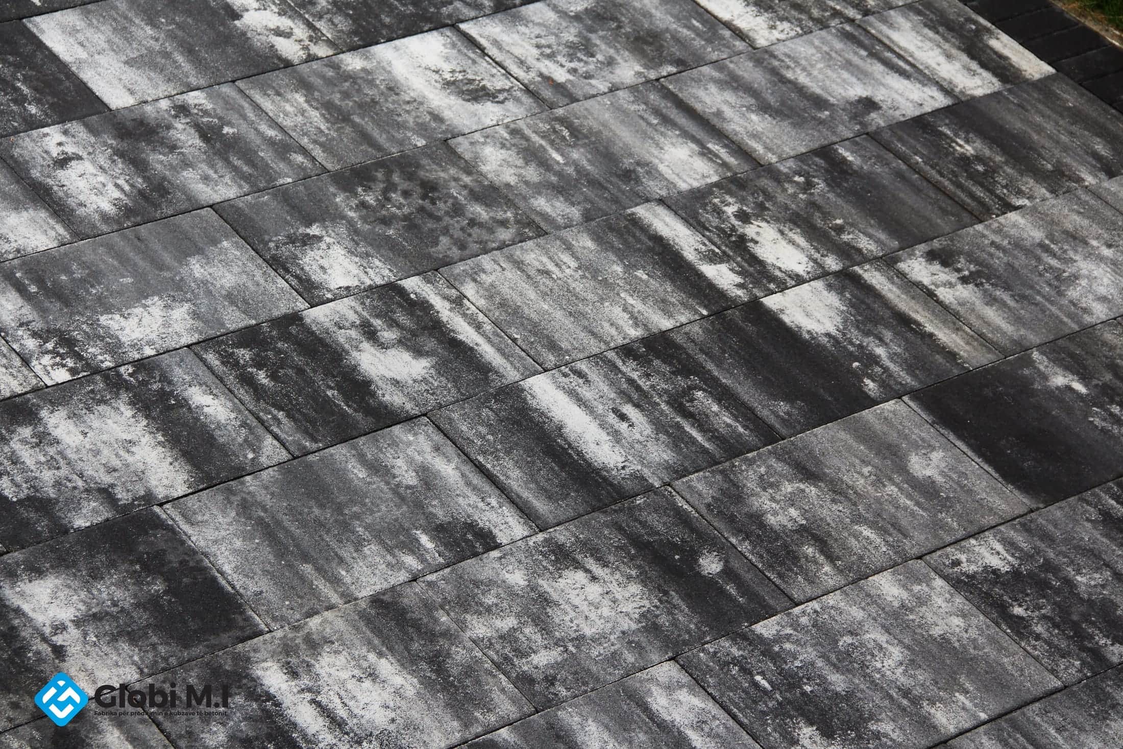 Close view of large grey slabs laid in a staggered bond.