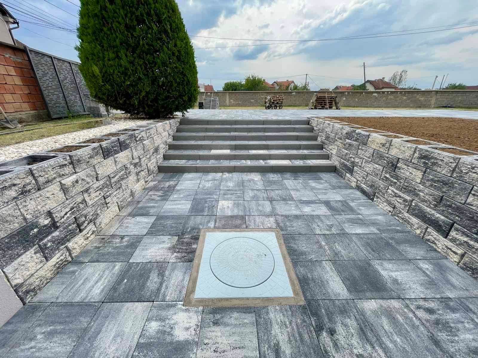 Wide concrete steps between two levels of a paved area.