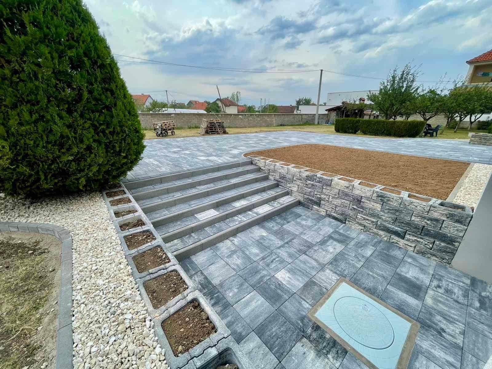 Square opening of soil and gravel left within the paved surface.