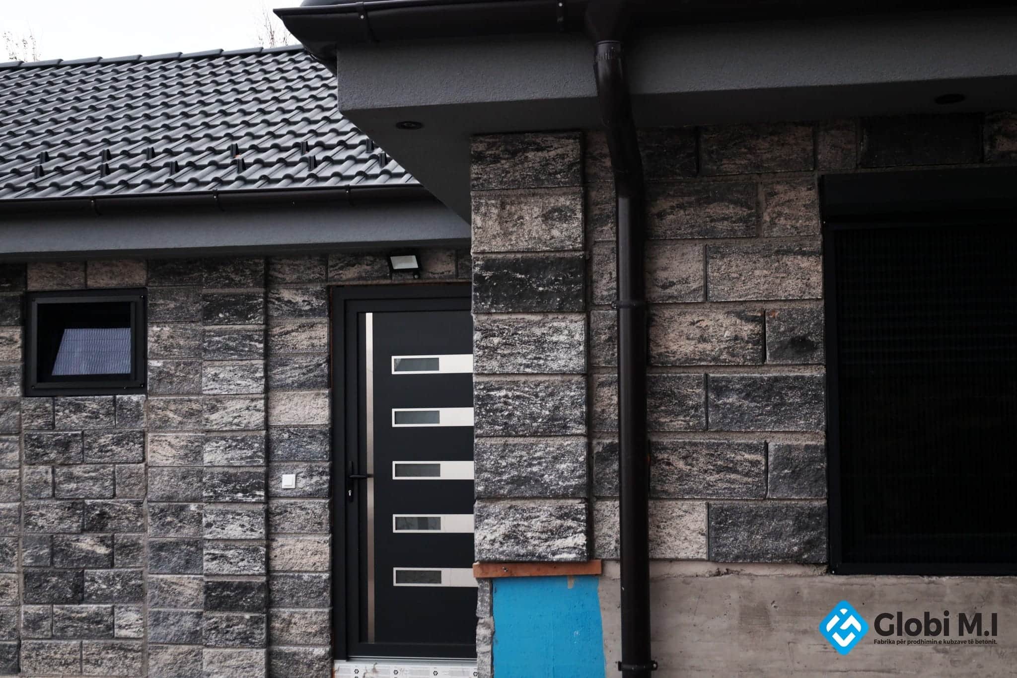 Building corner with a rough concrete wall and an entrance door.