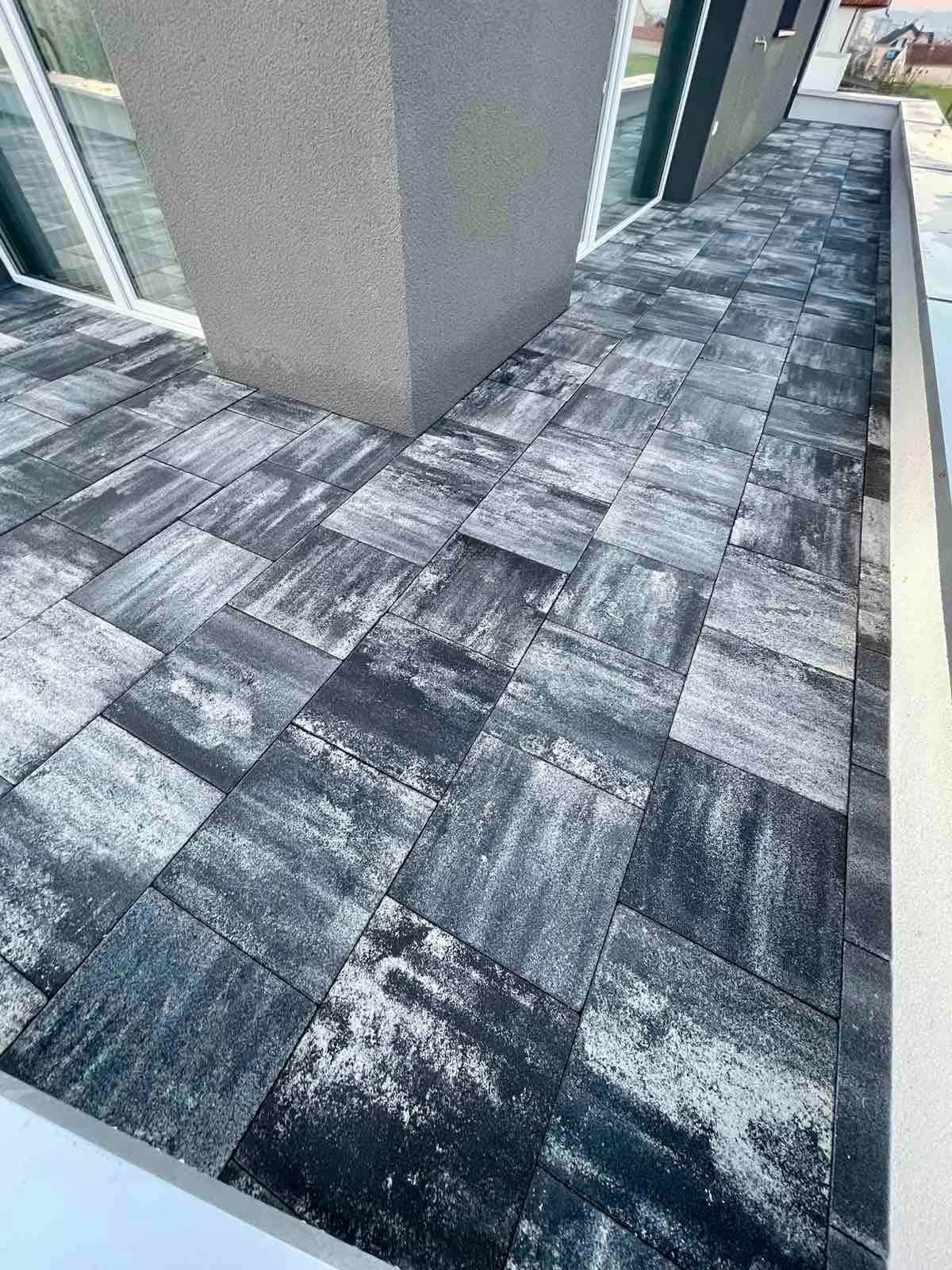 The paving turning around a corner pier of the house.