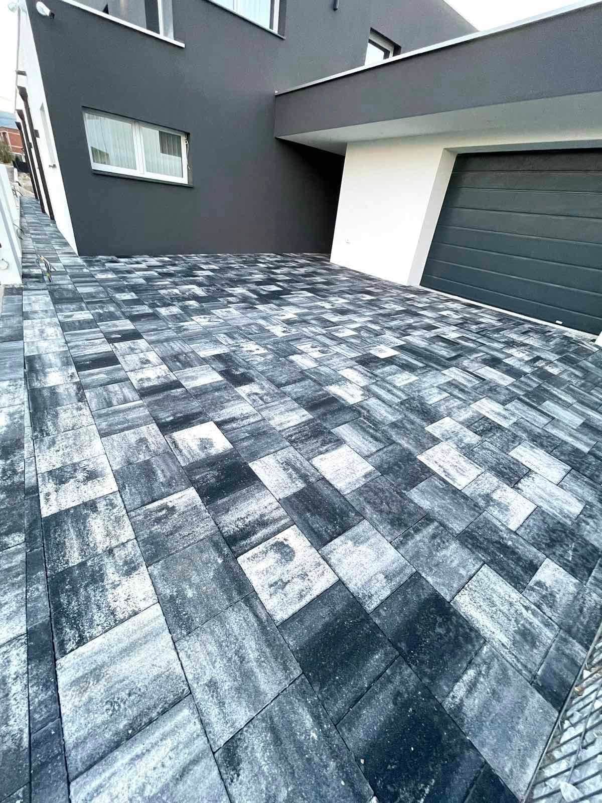 Paved area in front of the house, before the garage door.