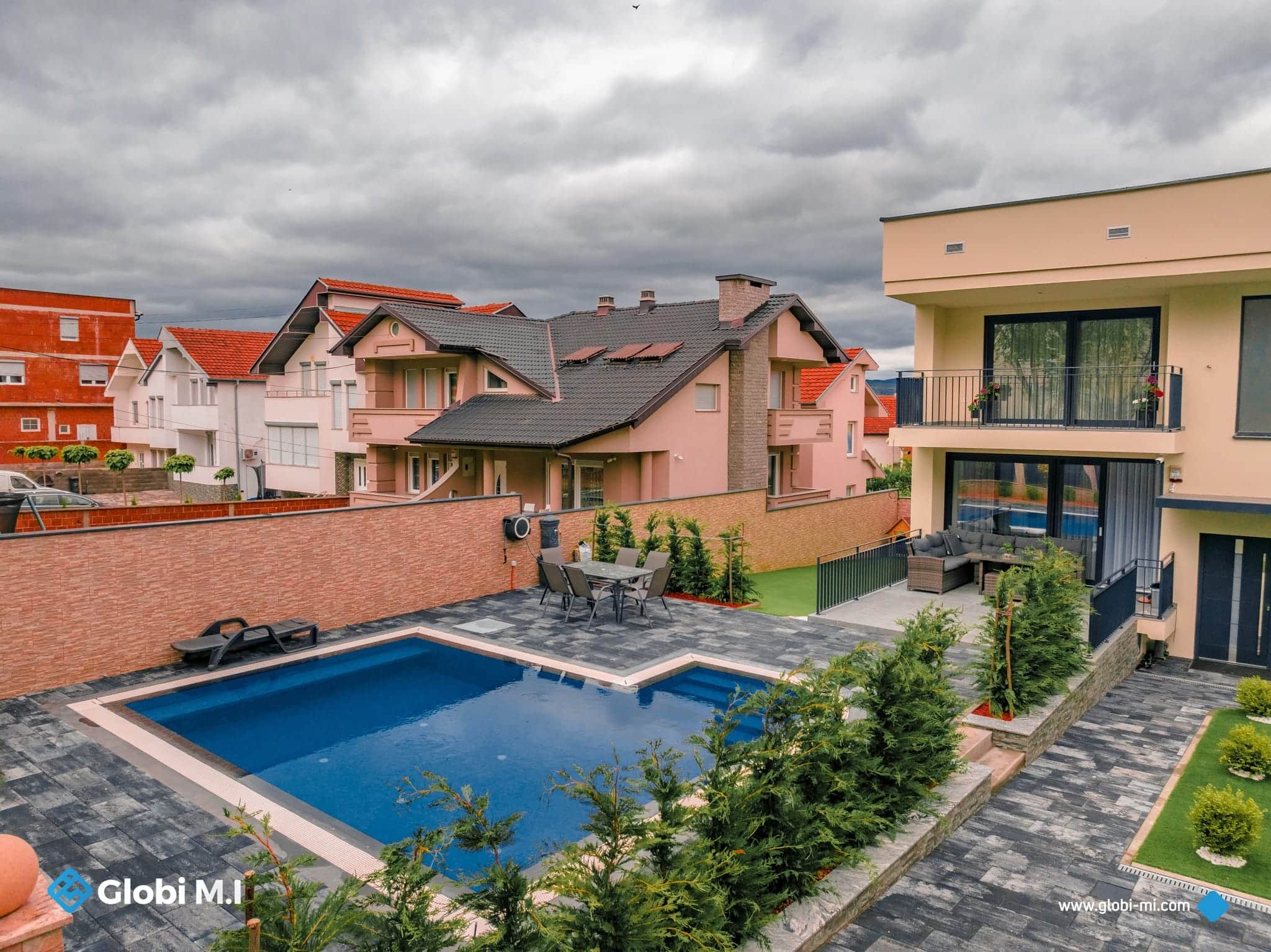 Private house with a paved outdoor area and a pool.