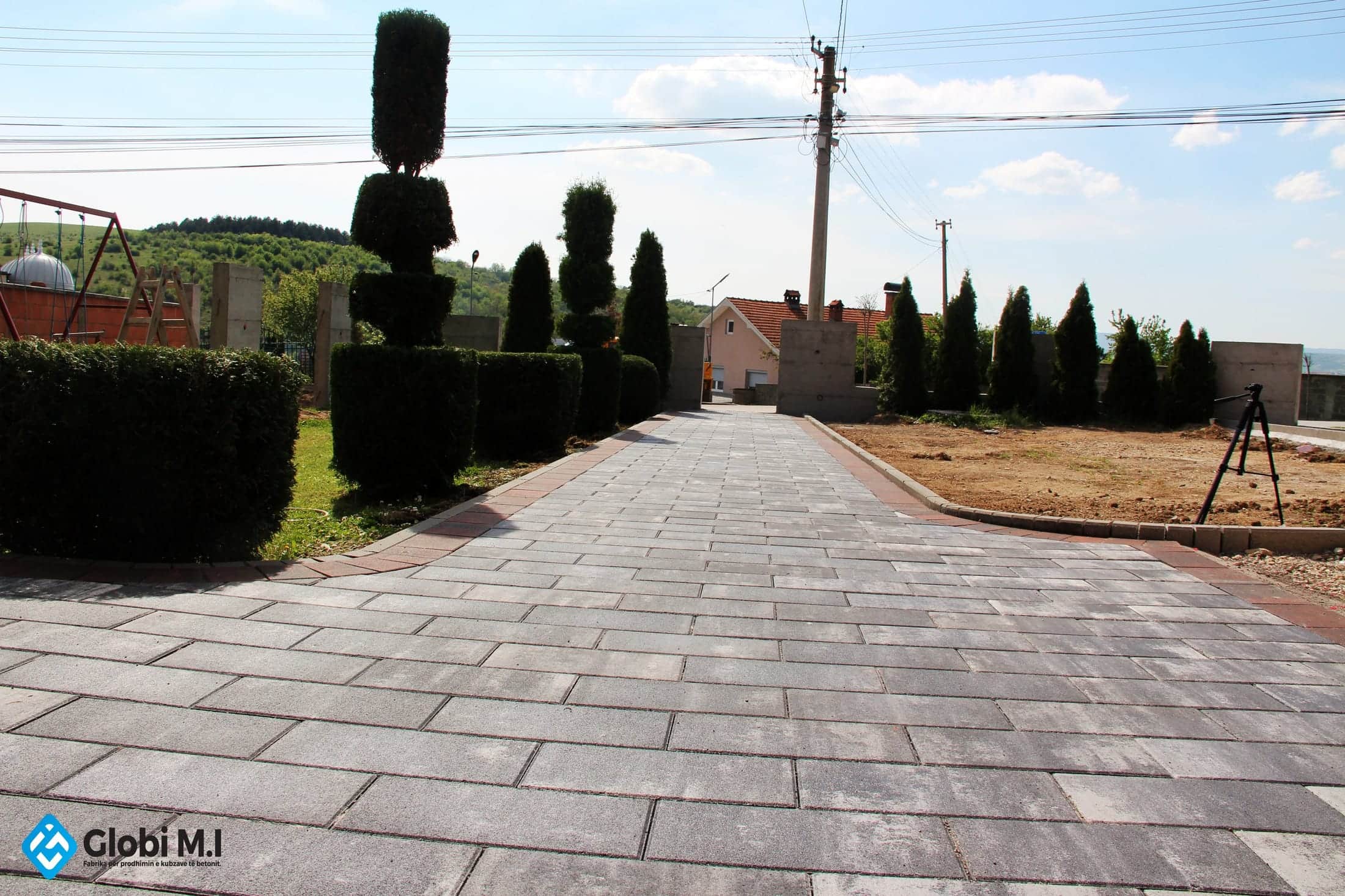 Paved driveway opening toward the gate and the street.