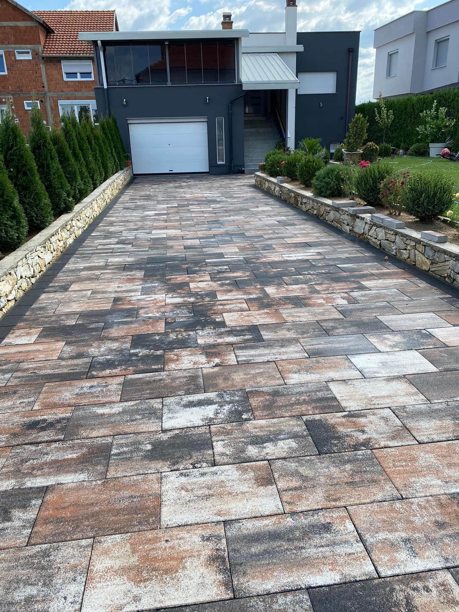 Paved drive at a dark-clad house with a white garage door.