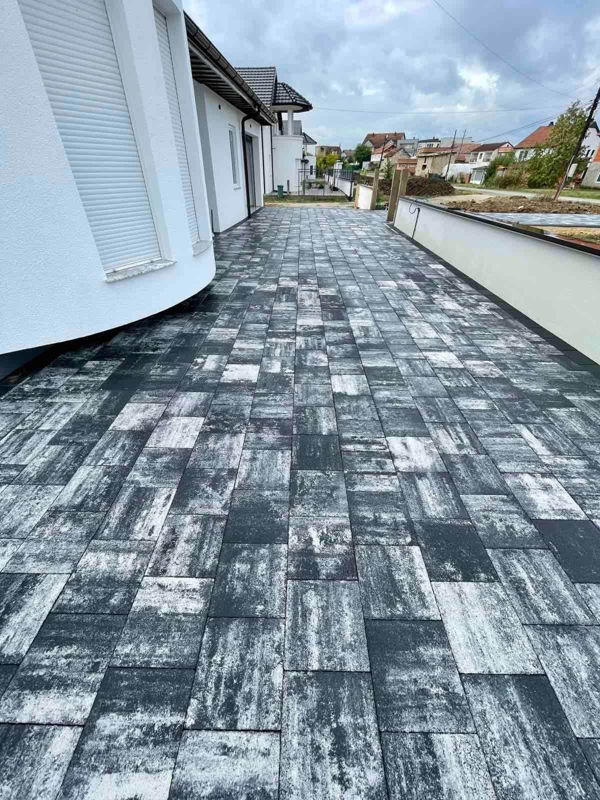 Paving following the curve of the white house wall.