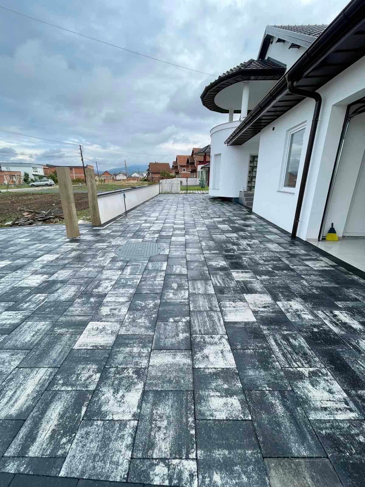 Paving running along the side of the house toward the back.