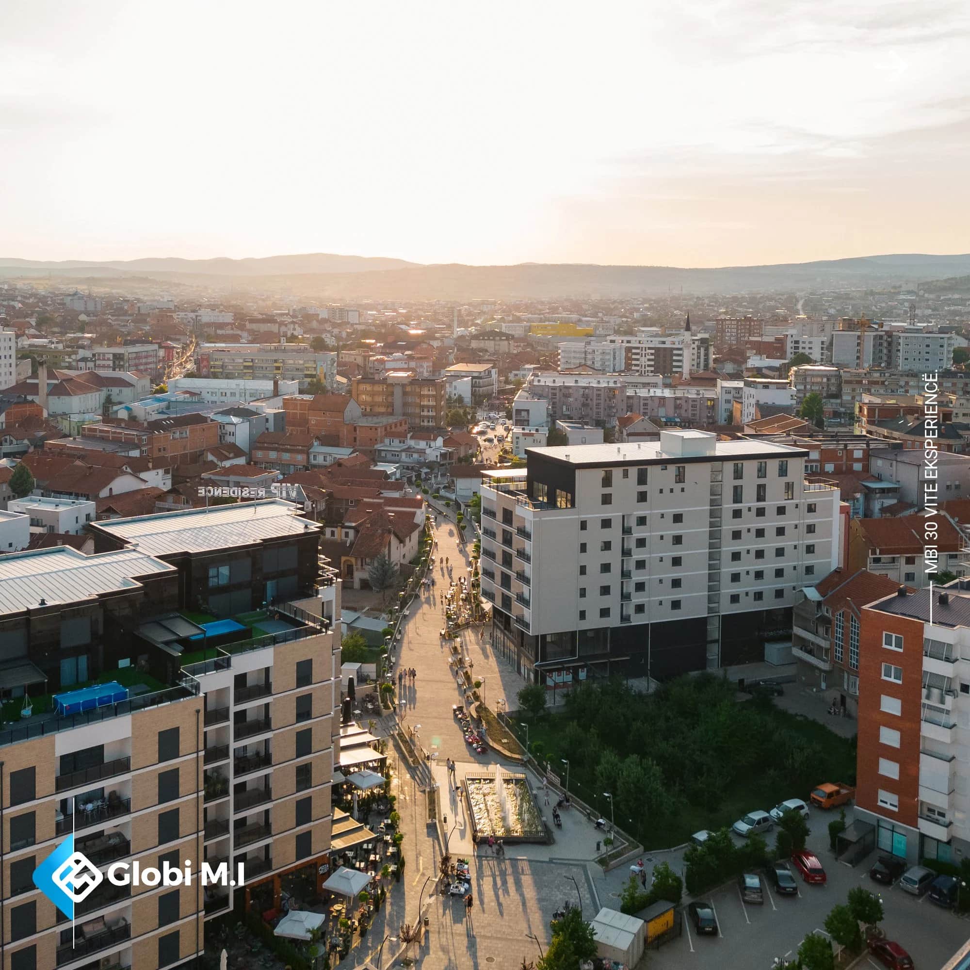 Gjilan aus der Luft am Abend, mit der Fußgängerachse zwischen den Gebäuden.