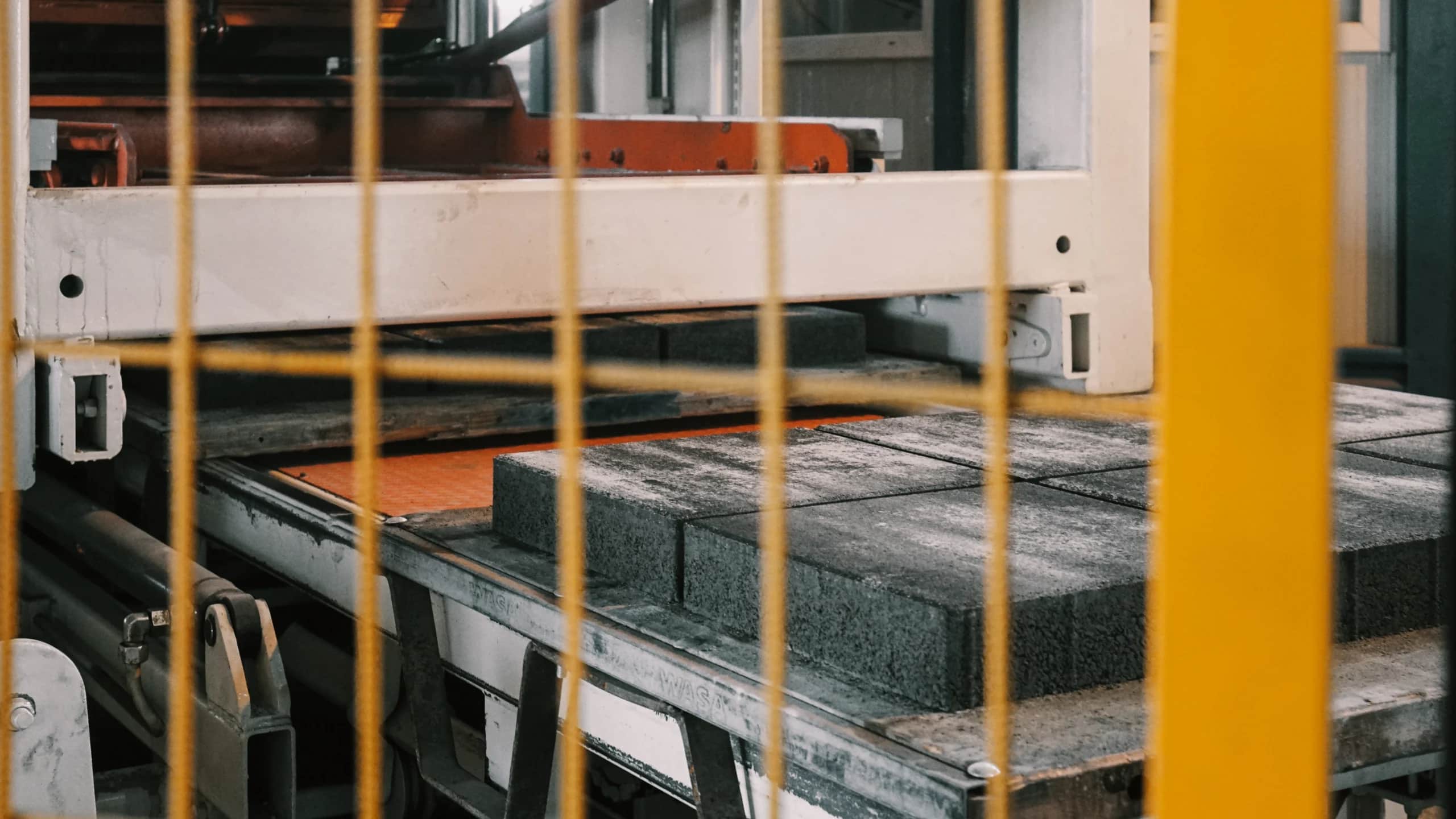 Just-pressed concrete pavers still on the board