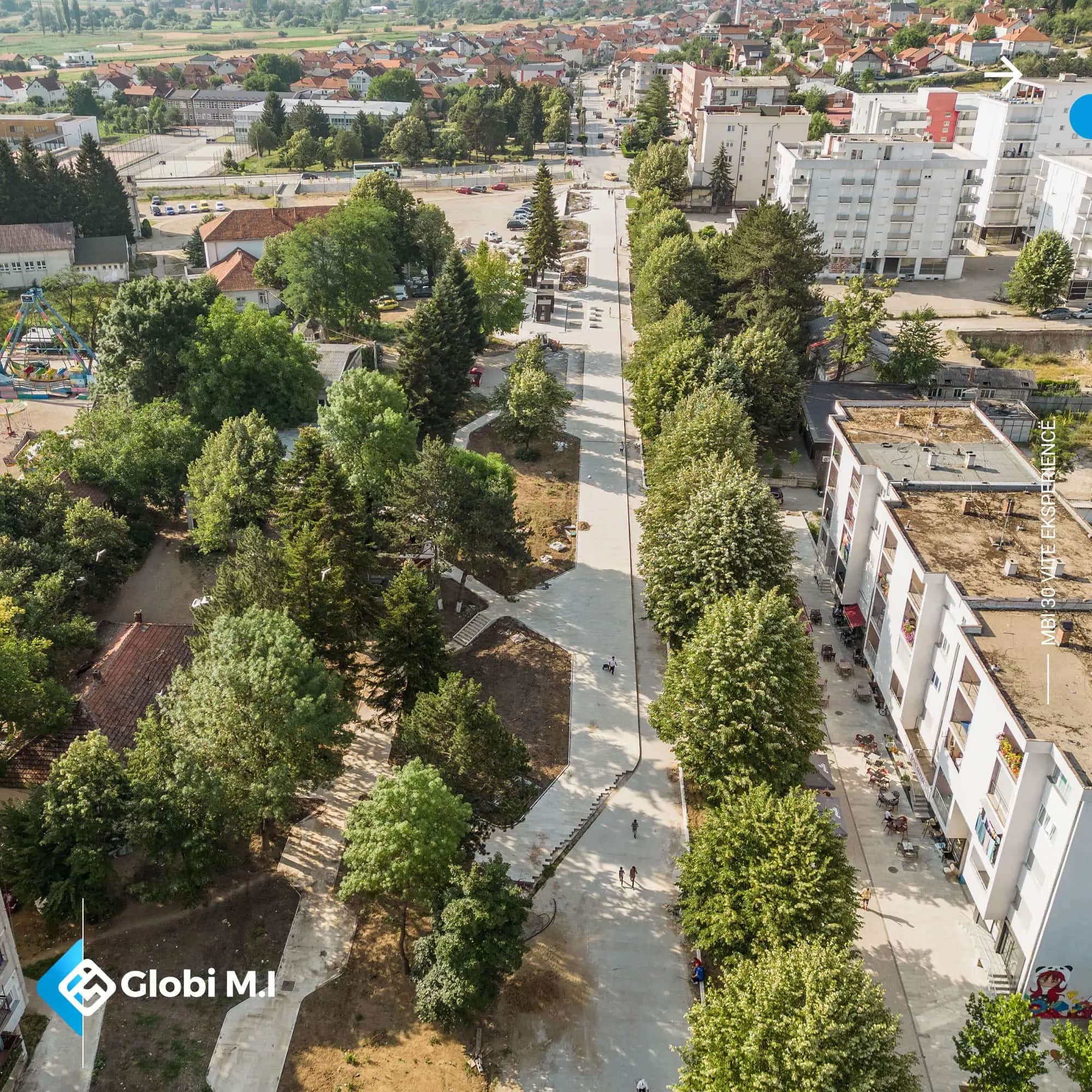 Kamenicë Boulevard from the air, with trees, buildings and paved surface.