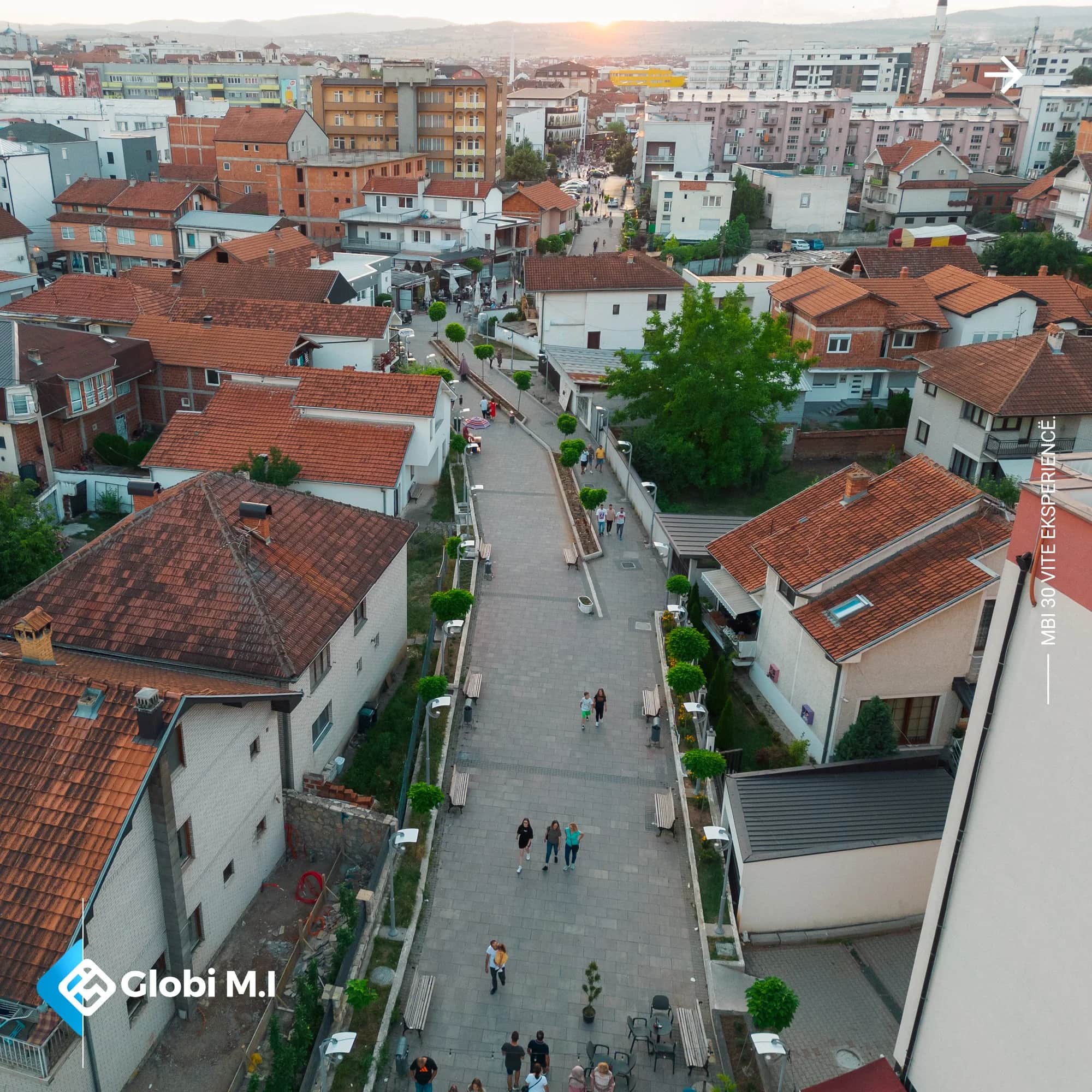 Paved pedestrian street in Gjilan seen from the air, between houses.
